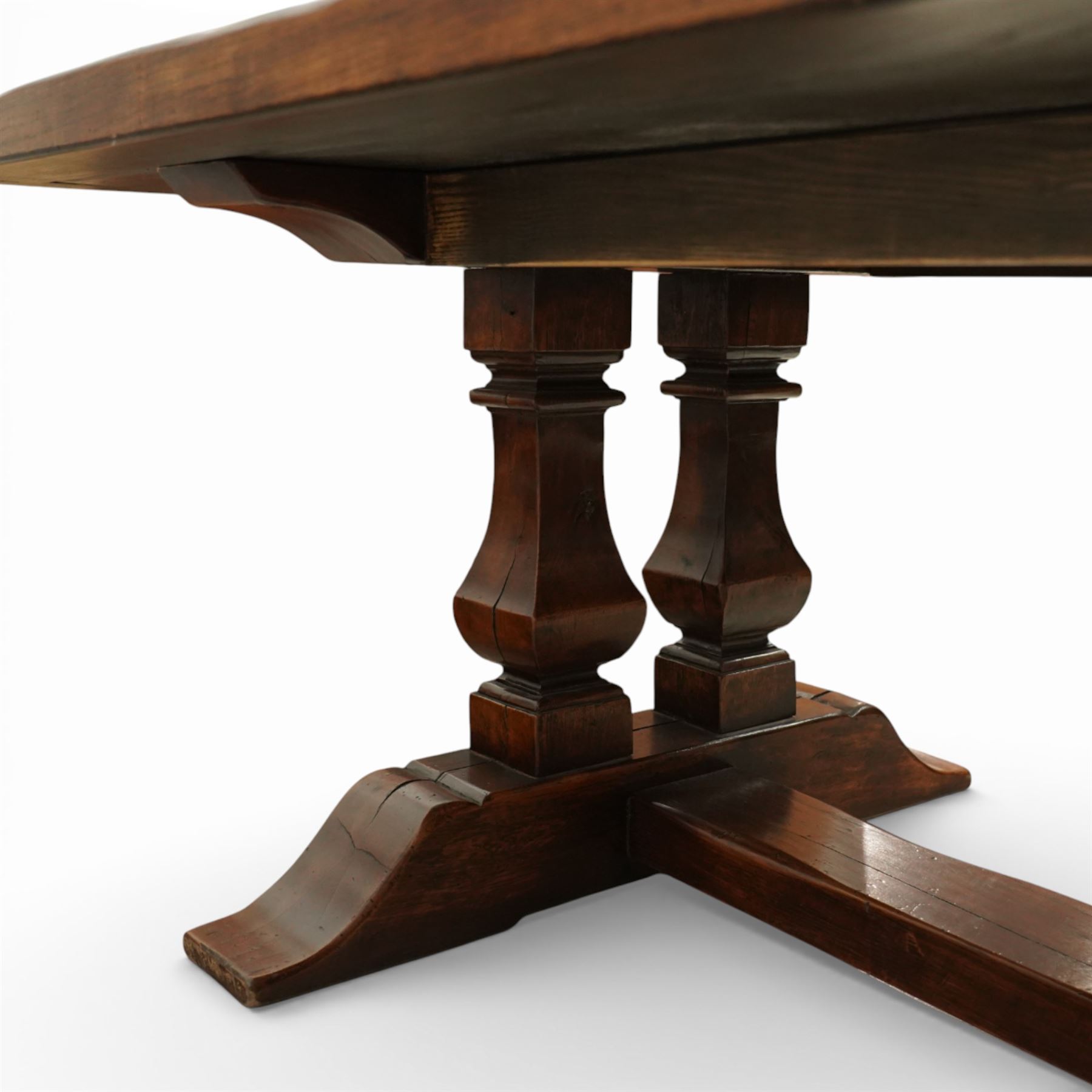 Country House 12' oak and fruitwood refectory dining table, the substantial rectangular plank top with cleated ends and chamfered edge, raised on twin trestle end square tapering and turned baluster supports with sledge feet and chamfered united by a long stretcher rail