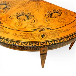 20th-Century Louis XVI-Style satinwood and penwork circular table or pair of console tables, the circular quarter-veneered top decorated in penwork with a central classical mask head motif within scrolling foliate and anthemion ornament on a contrasting black ground, above a conforming frieze decorated with Greek key-type scrolls. Raised on square tapering legs, each with an upper block panel decorated with compass-star motifs.