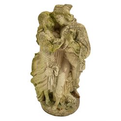 Composite stone garden figure of two lovers, on naturalistic setting decorated with flower heads