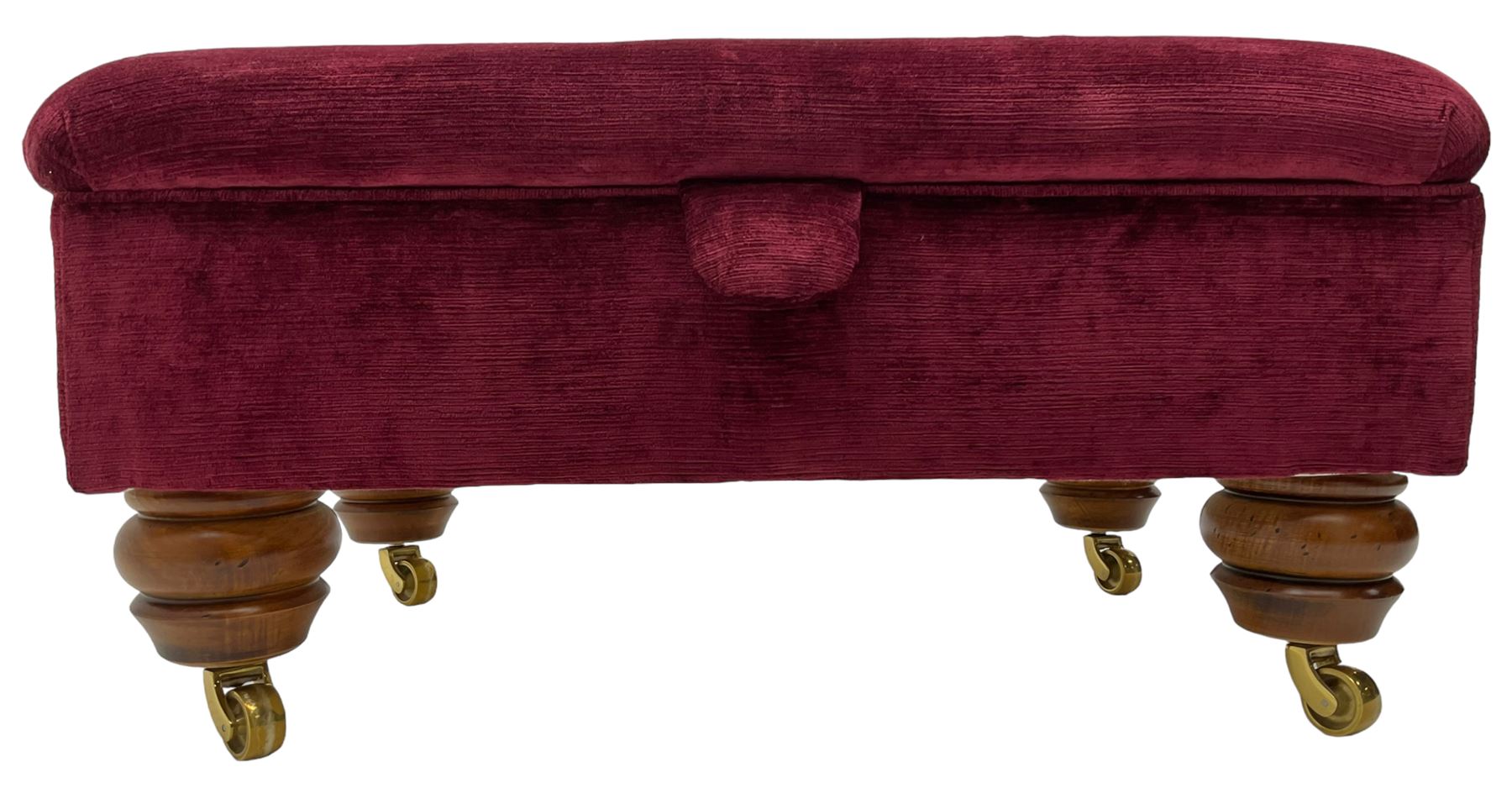 Duresta - traditional shape armchair upholstered in burgundy red velvet, on square tapering front supports (W88cm, H85cm, D103cm); together with a matching rectangular footstool with hinged seat, on turned feet with brass castors (73cm x 54cm, H38cm)