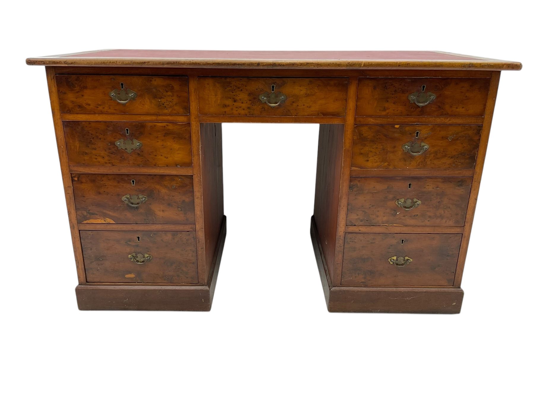 Late 19th to early 20th century walnut pedestal desk, rectangular top inset with red tooled leather writing surface, over a central frieze drawer flanked by two pedestals, each fitted with four graduated drawers with brass escutcheons and drop handles, the whole raised on a plinth base