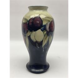 Moorcroft Wisteria pattern vase, circa 1916, lender baluster form, decorated with foliage, in tones of creams and purples, on a blue ground, with painted and impressed sign beneath, H23cm
