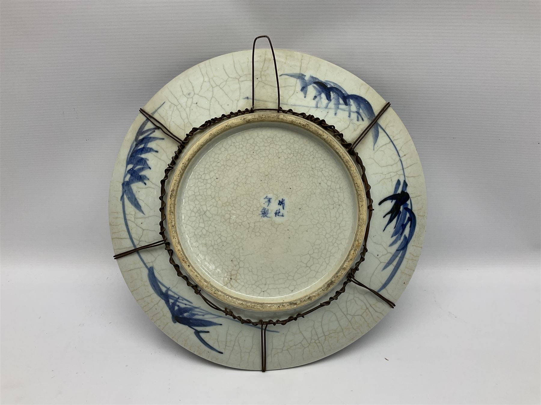 20th century Chinese blue and white crackle glaze charger, decorated with peonies, prunus blossom, and rockwork, within simulated bronze border, with character mark verso, D34cm