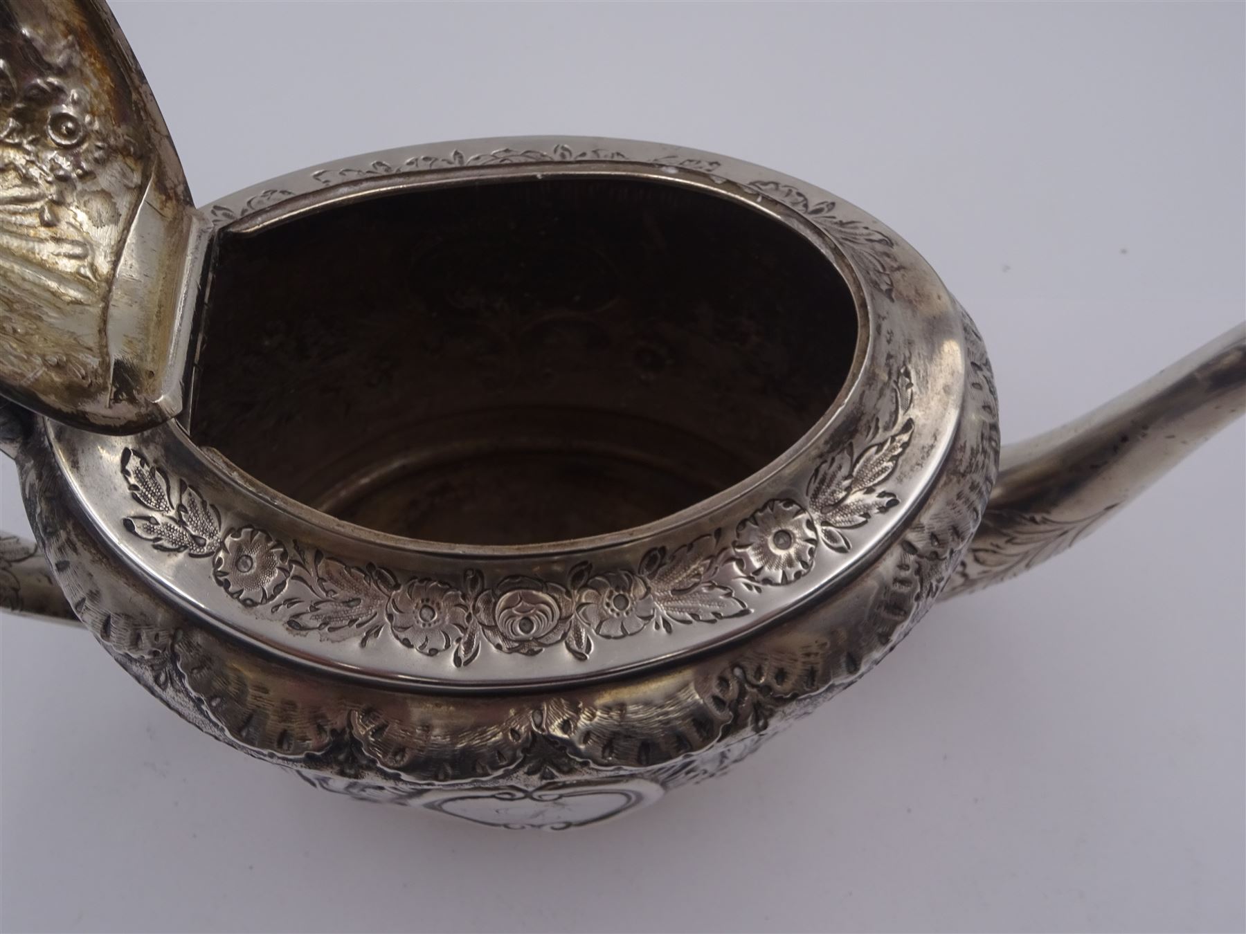 George III silver teapot, of oval form, with embossed foliate, floral and scroll decoration and engraved central cartouche, with acanthus capped C handle with ivory insulators, hallmarked John Emes, London 1807 This item has been registered for sale under Section 10 of the APHA Ivory Act

