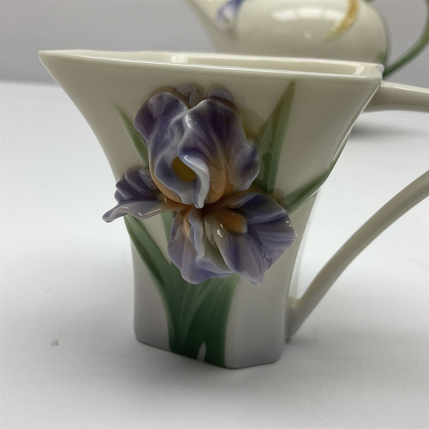 Franz Teapot decorated with dragonflies, together with a matching sucrier and cover and a cup and saucer in Iris pattern, all with printed mark beneath 