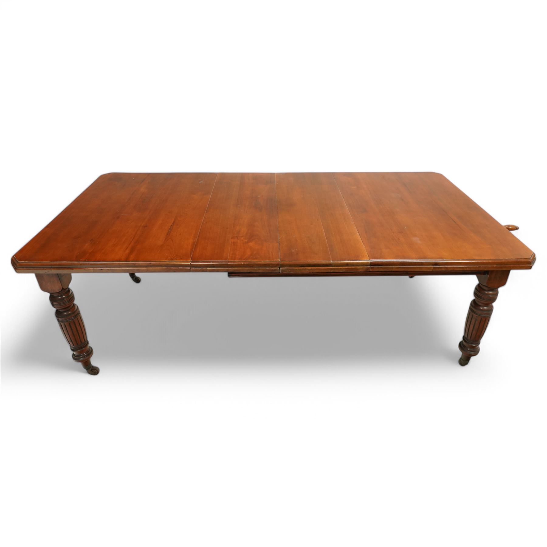 Late Victorian mahogany extending dining table with two leaves, moulded chamfered edge above, turned and reeded legs and ceramic castors, winding handle included, 205cm extended, 132cm closed, 102cm wide, 73cm high