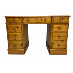 Polished pine twin pedestal desk, fitted with nine drawers, inset green leather top