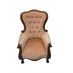 Victorian walnut framed armchair, shaped back with carved and scrolled arm terminals, upholstered in buttoned pale pink fabric, raised on cabriole supports terminating in castors