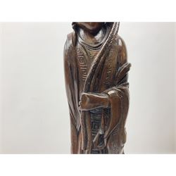 Two large hardwood Oriental figures carved as a man and woman donning robes upon naturalistic plinths, tallest