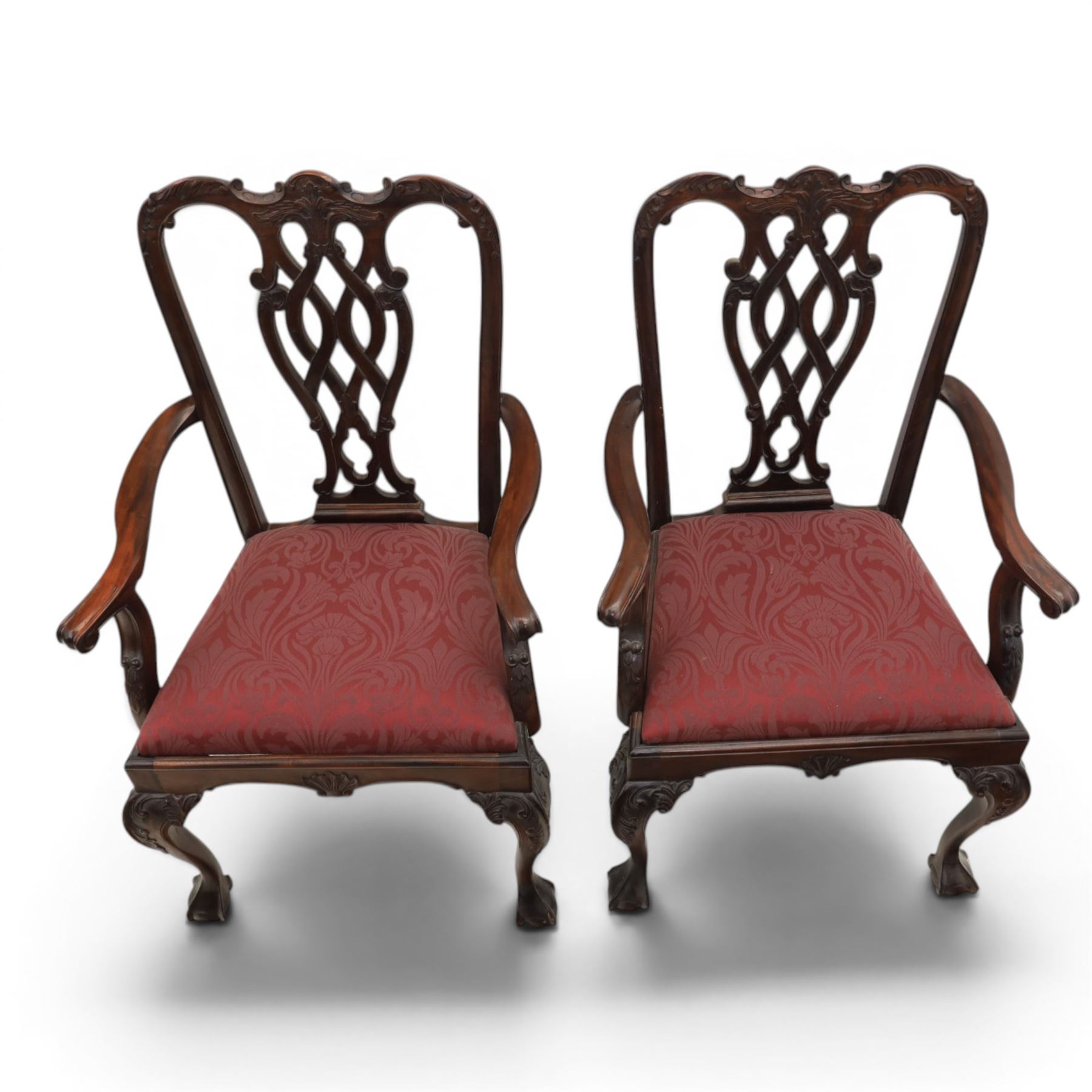 Chippendale design set of ten (8+2) mahogany dining chairs, serpentine cresting rails with carved detail over pierced ribbon-tied splats, red damask upholstered drop-in seats, on cabriole supports with acanthus carved knees and claw and ball feet
