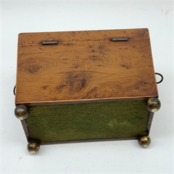 George III burr yew tea caddy, of sarcophagus form with lion mask ring handles and four brass ball feet, the hinged lid opening to reveal two compartments with cross-banded lids and traces of metallic paper lining, L19cm