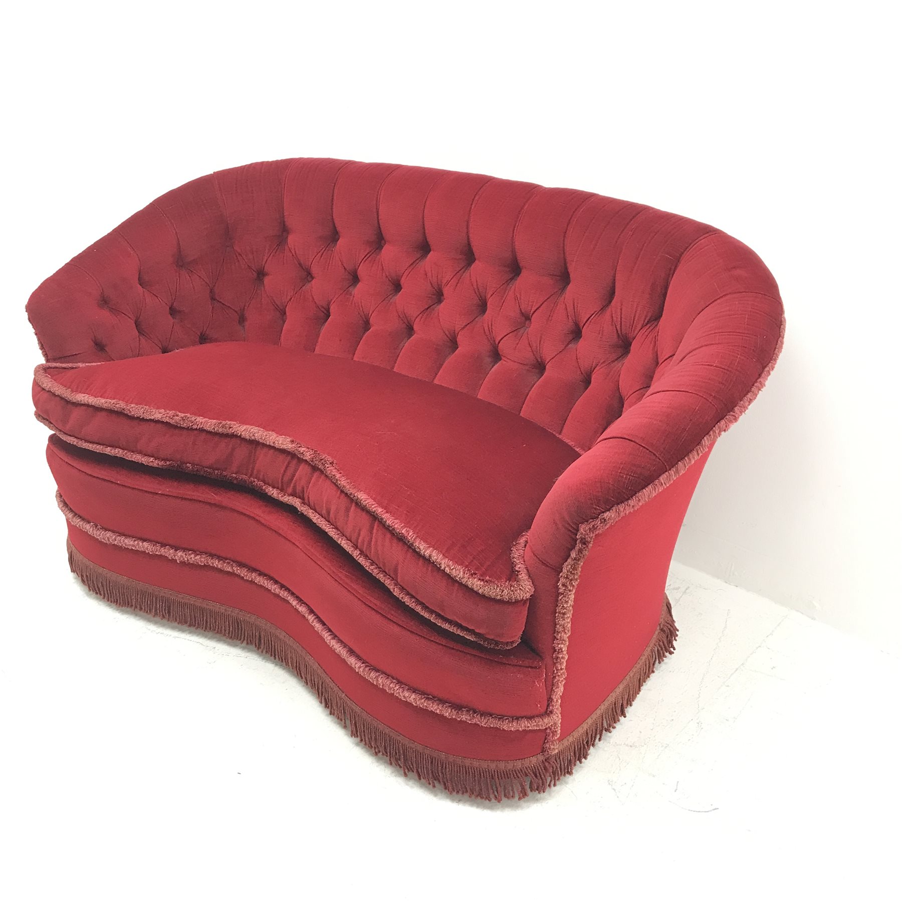 Early 20th Century kidney shaped two sofa upholstered in deep buttoned red fabric, W147cm
