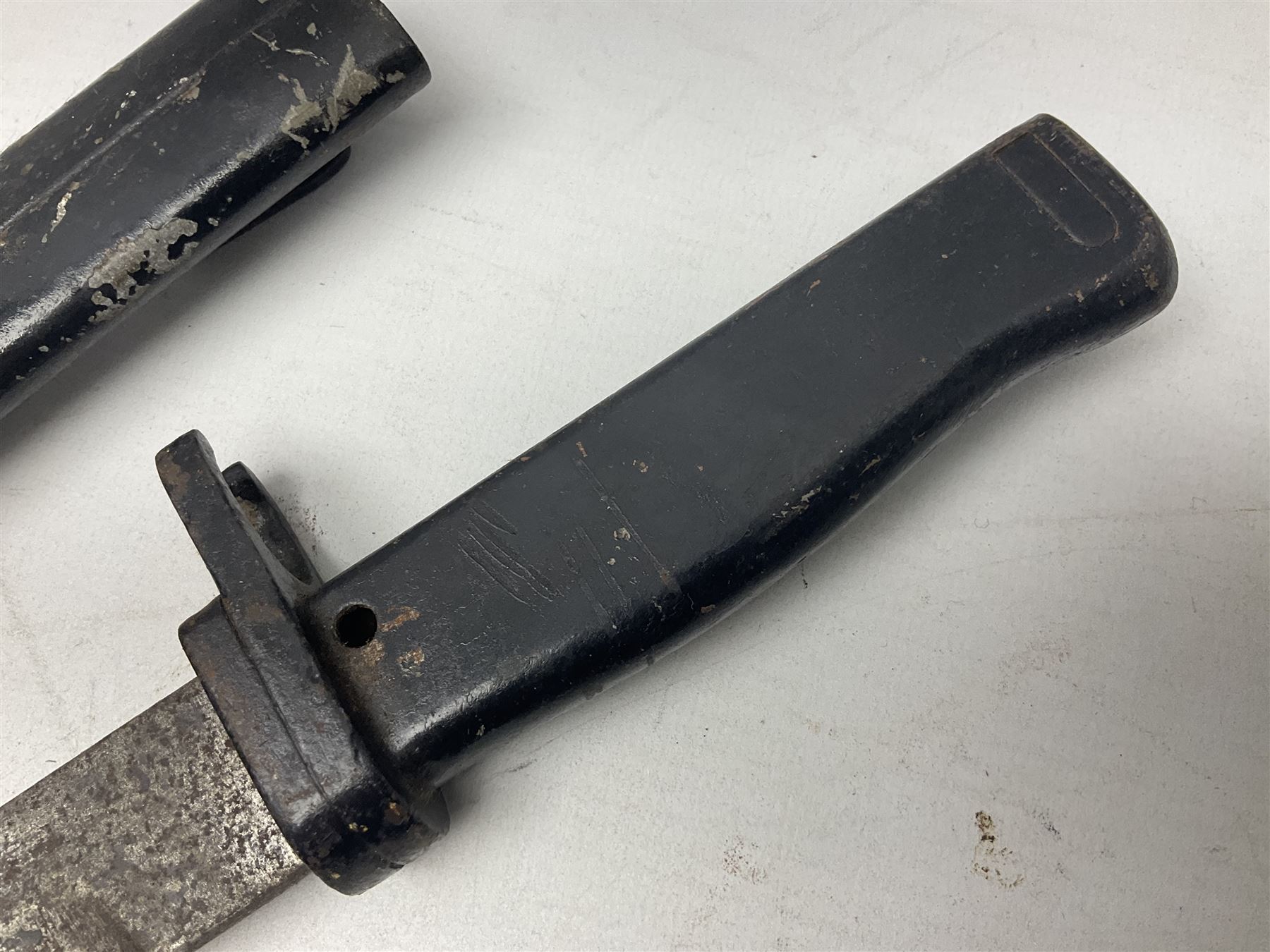 British No 7 MKI knife bayonet with 20cm single edged fullered clipped point blade;  blackened steel, large muzzle ring cross-guard; blackened swivelling pommel marked 'F5H'; red Tufnol composite grips; in blackened steel scabbard L33cm overall; British Pattern 1888 bayonet with scabbard; and German Ersatz bayonet with scabbard (3)