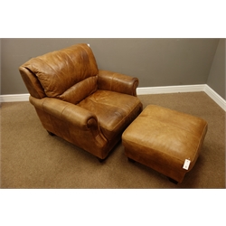  Wide seat traditional shaped armchair and matching footstool upholstered in tan leather  
