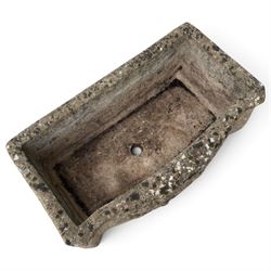 Two weathered composite stone garden trough planters, comprising a low serpentine trough relief moulded with rocaille, shell and foliate ornament (W55cm D32cm H19cm); the plain rectangular trough decorated with four moulded Yorkshire rose medallions to each side (W51cm D26cm H25cm)