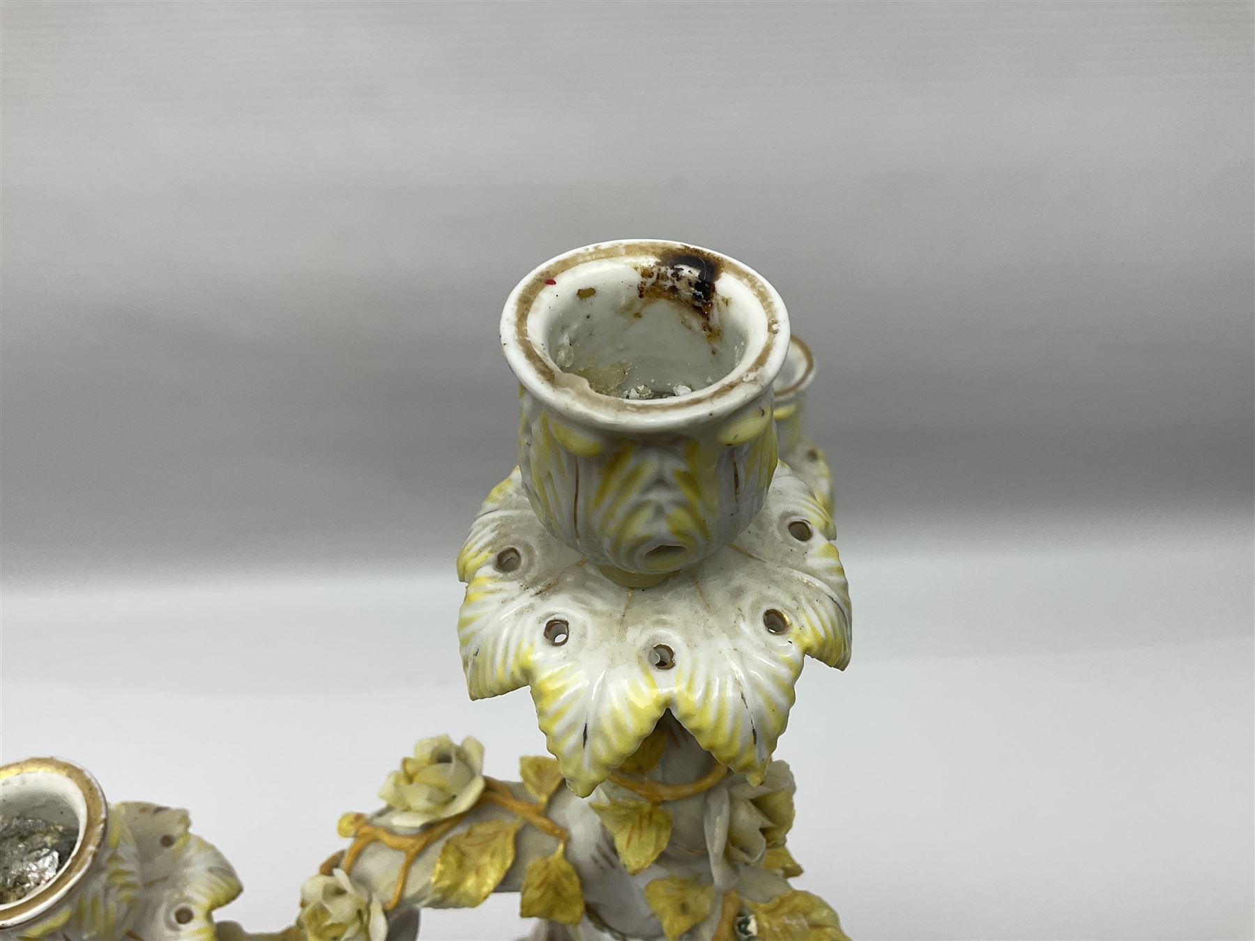 Dresden style candelabra, the central stem bordered by three branches, decorated with cherubs and yellow roses, H48cm