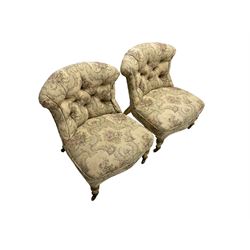 Pair Victorian giltwood nursing chairs, upholstered in buttoned floral pattern fabric, turned front supports on brass castors 