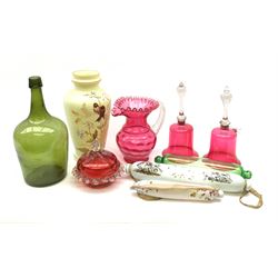 A group of 19th century glass, comprising two milk glass love token rolling pins, a green glass example, an opaque glass vase painted with birds and flowers, a green bottle, pair of cranberry glass bells with clear handles, cranberry pot and cover, and later cranberry jug. 