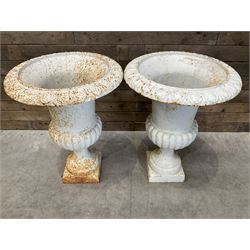 Pair of large Victorian design white painted cast iron campana shaped garden urns, egg and dart rim over a gadrooned underlobe, tapering column on square plinth base