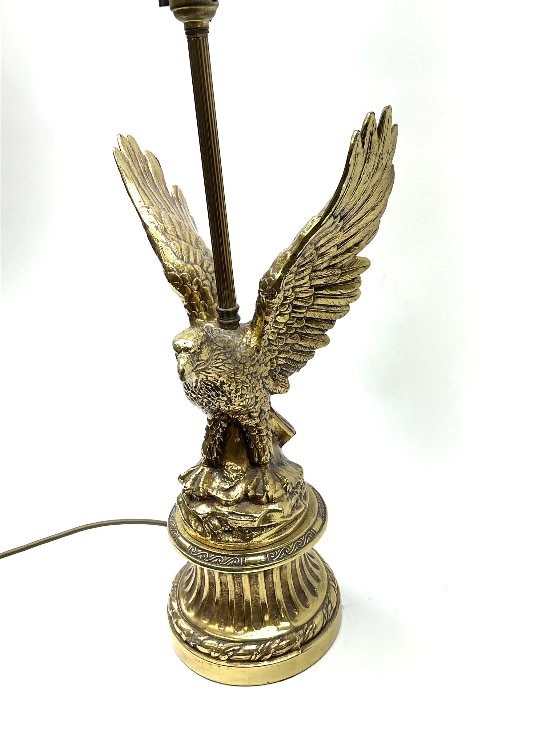 A brass table lamp modelled in the form of an eagle upon a circular base, overall H73cm.