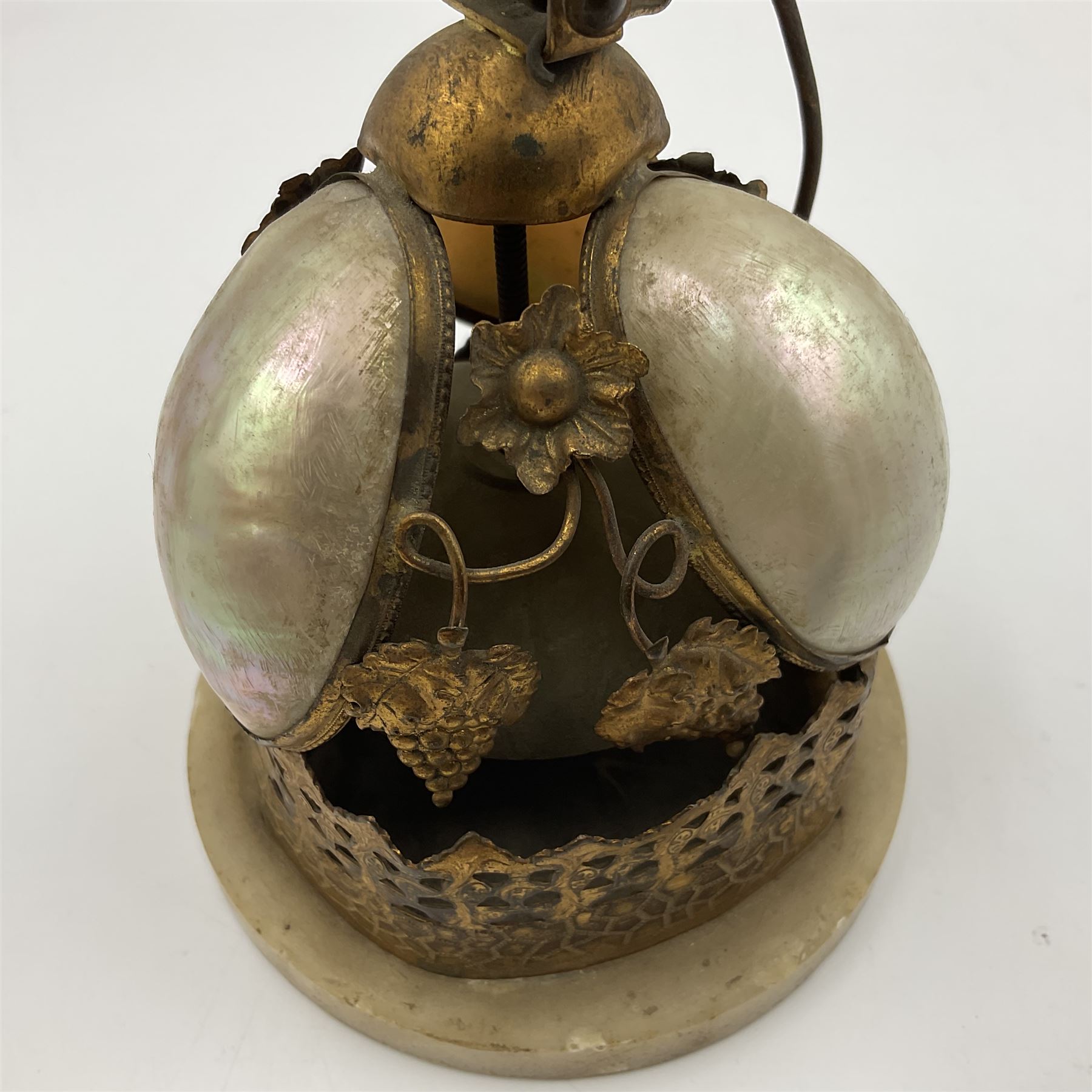Victorian evening dinner bell, with three mother of pearl shells, floral and grape gilt decoration, and bird finial, raised upon a circular soapstone base with gilt pierced gallery, H14cm