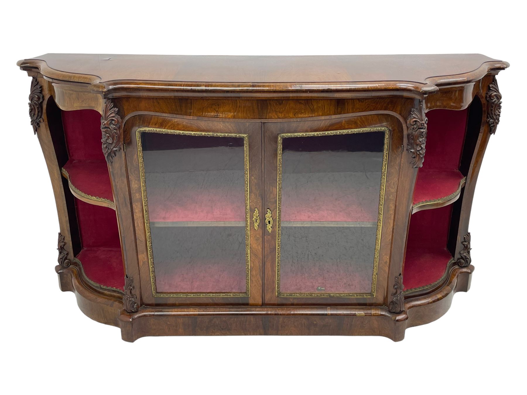 19th century rosewood buffet credenza, bombe form with shaped and moulded top, two central glazed doors with foliate moulded gilt slips, the red fabric-lined interior fitted with a single shelf, flanked by open shelves with raised gilt metal lips, the uprights decorated with shell and flower head carved cartouche mounts, acanthus leaf scroll carved lower mounts, on shaped and moulded plinth base 
