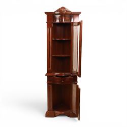 Victorian design mahogany corner cabinet, shaped carved cresting above bowed glazed upper door, with panelled side uprights, lower drawer over cupboard door decorated with floral marquetry, on plinth base