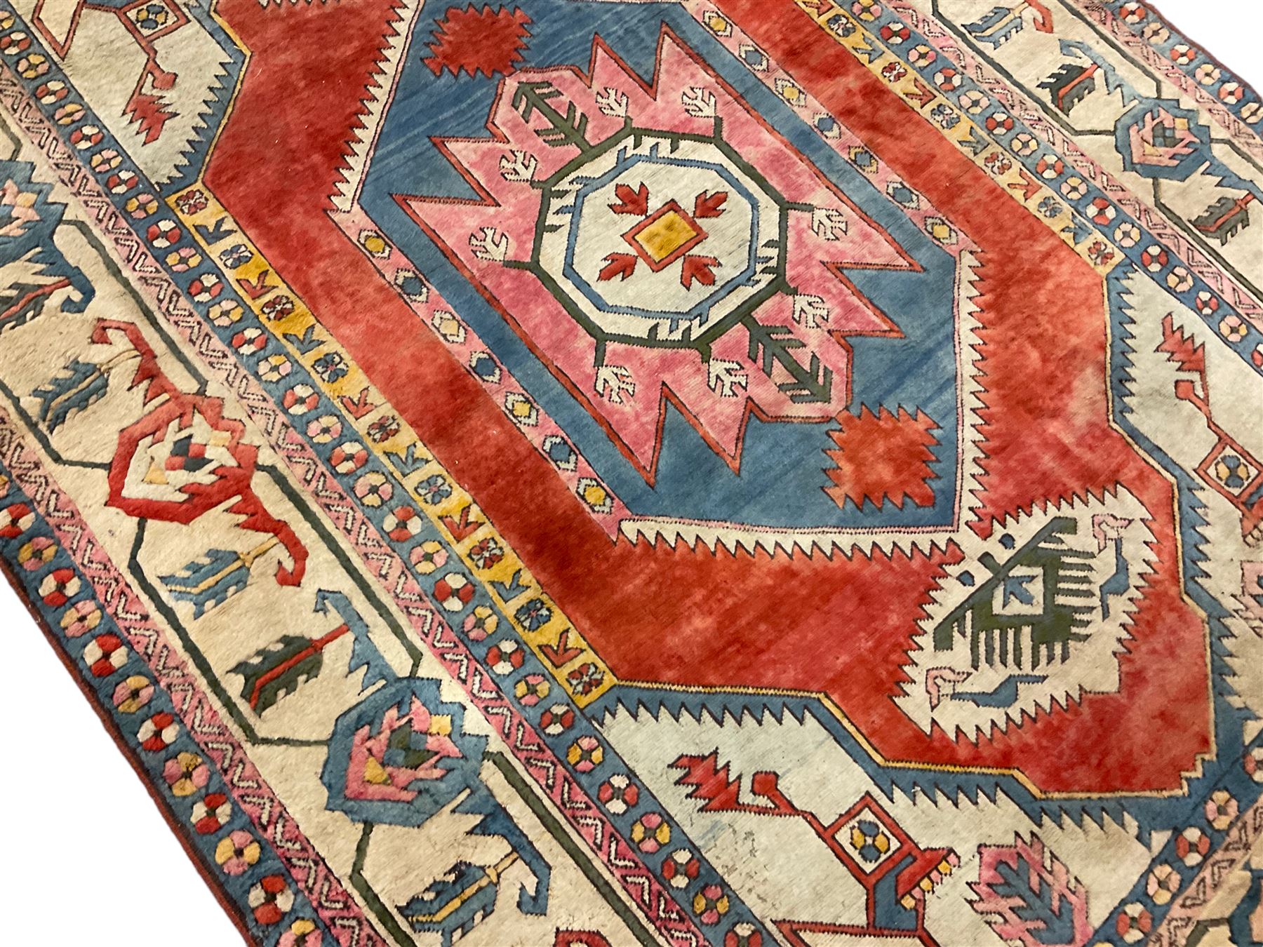 Anatolian Turkish ivory ground carpet, the central geometric pole medallion within an amber field, the guarded border decorated with stylised plant motifs surrounded by bands of repeating flower heads
