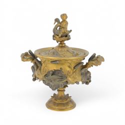19th century gilt bronze twin handled urn, the removable cover with foliate decoration and finial modelled with a putti and swan, the body decorated in relief with swans and reeds, upon a circular foot, H19cm