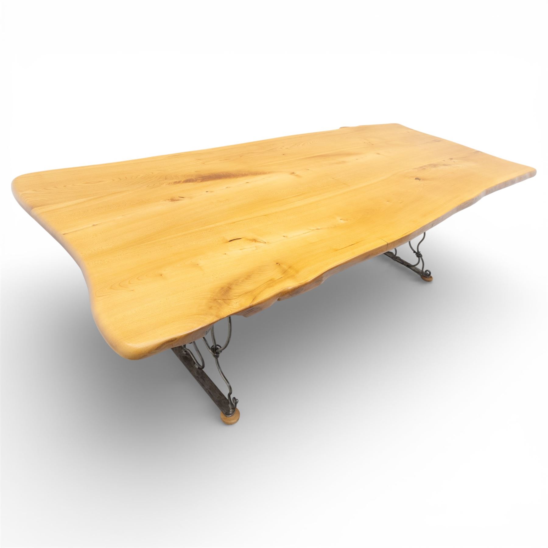 Paul Hodgkiss Designs of Glasgow - contemporary shaped elm dining table with wrought iron base; with set ten (8+2) matching high-back dining chairs, table of organic form above an elaborate wrought iron supports, with central elm stretcher, the chairs with en suite with matching wrought iron work burred elm headrest, purple velour upholstery with drop in seat     

Table: W 102cm, L 243cm, H 74cm
Chairs: W 56cm, D 52cm, H 130cm