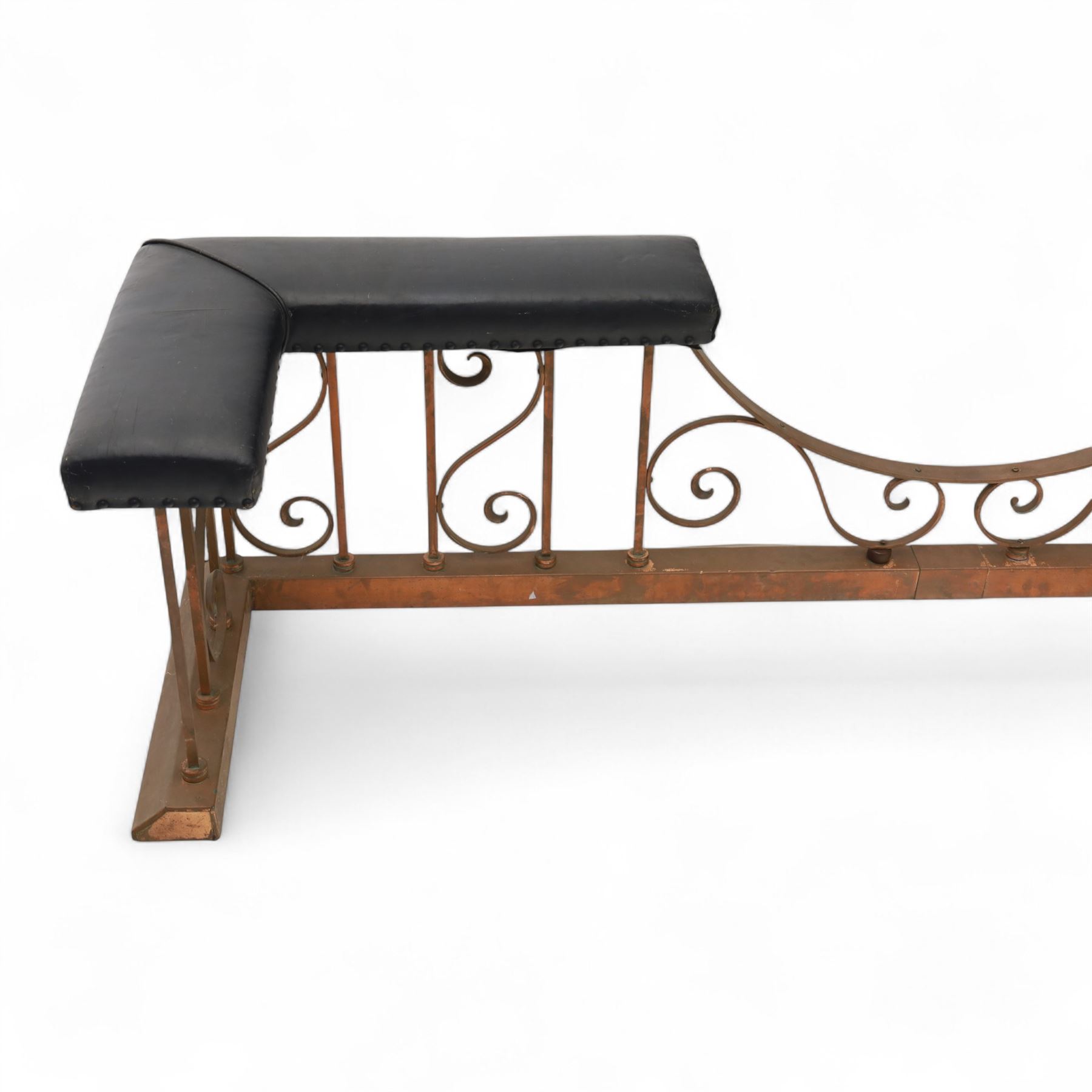 Early 20th-century Arts & Crafts copper club fender, of long serpentine form, scrolling uprights and a shaped centre support, the top rail fitted with four upholstered padded seat sections, raised on a stepped plinth base, inner dimensions 192x43cm 