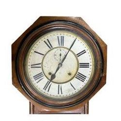 American - Late 19th century Ansonia 8-day wall clock, with a hexagonal wooden dial surround and circular spun bezel, glazed case door and visible pendulum,  two part dial with Roman numerals, minute track, spade hands and seconds dial, twin train spring driven movement striking the hours on a gong.
