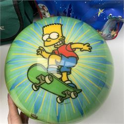 Two The Simpsons 'The Bowling Club' tenpin bowling balls, the first an undrilled example depicting Bart Simpson on a green ground, the second a drilled example depicting the Simpsons family on an orange ground, both in Simpsons The Bowling Club bags, together with a Disney Monsters, Inc. tenpin bowling ball, in matching bag and a Maxim tenpin bowling ball