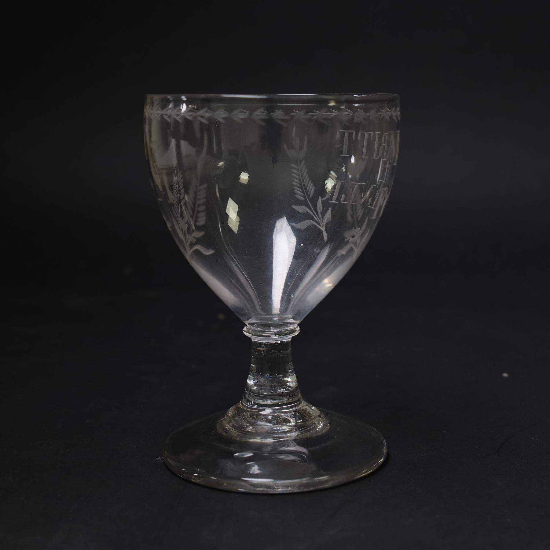 Early 19th century electioneering glass rummer, circa 1800-1830, the funnel bowl engraved with the inscription 'MORRITT FOREVER', and initials 'Y I M' verso, within leafy sprigs and beneath a husk band to rim, upon a plain short spreading stem, upon conical foot, H13.5cm

John Bacon Sawrey Morritt (circa 1772–1843) of Rokeby Park was a traveller, classical scholar, landowner, politician, and friend of Sir Walter Scott. He sat in Parliament for Beverley (1799–1802) and later for Northallerton (1814–1818), periods when fiercely contested elections often produced engraved drinking glasses as campaign propaganda, which were distributed in taverns and at election dinners. Examples connected to local candidates such as this are particularly scarce and survive as rare intersections of political history and material culture. 