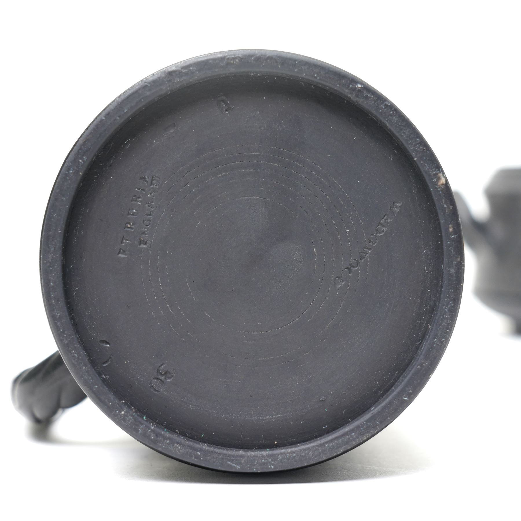 Four pieces of 19th century Wedgwood black basalt ware, c.1875, comprising larger and smaller jug, covered sucrier and teapot, each decorated with classical scenes in high relief, larger jug H13cm