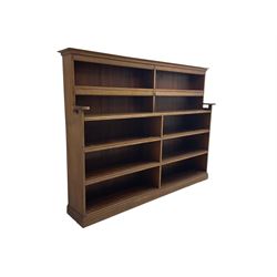 20th century oak double bookcase, ten shelves fitted with hinged spine covers, on moulded plinth base