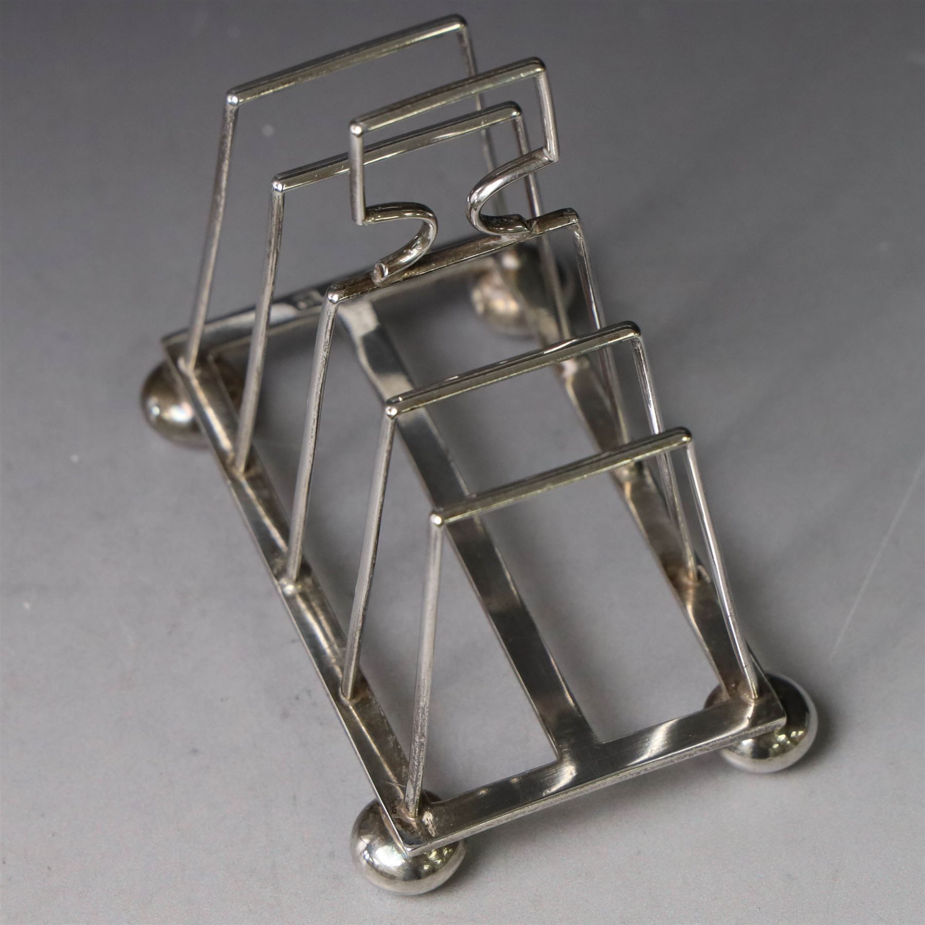 Victorian silver toast rack, with five angular bars and loop handle, upon four squat bun feet, hallmarked Thomas Hayes, Birmingham 1893, height including handle H10cm