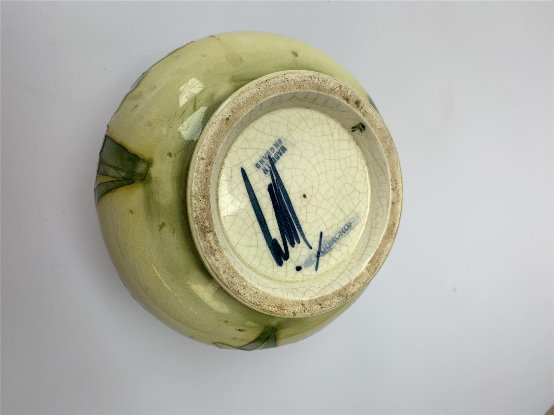 A Moorcroft vase, circa 1950, of squat bulbous form, decorated in the Orchid pattern upon a yellow glazed ground, with impressed and blue painted WM initials for Walter Moorcroft, H10.5cm. 