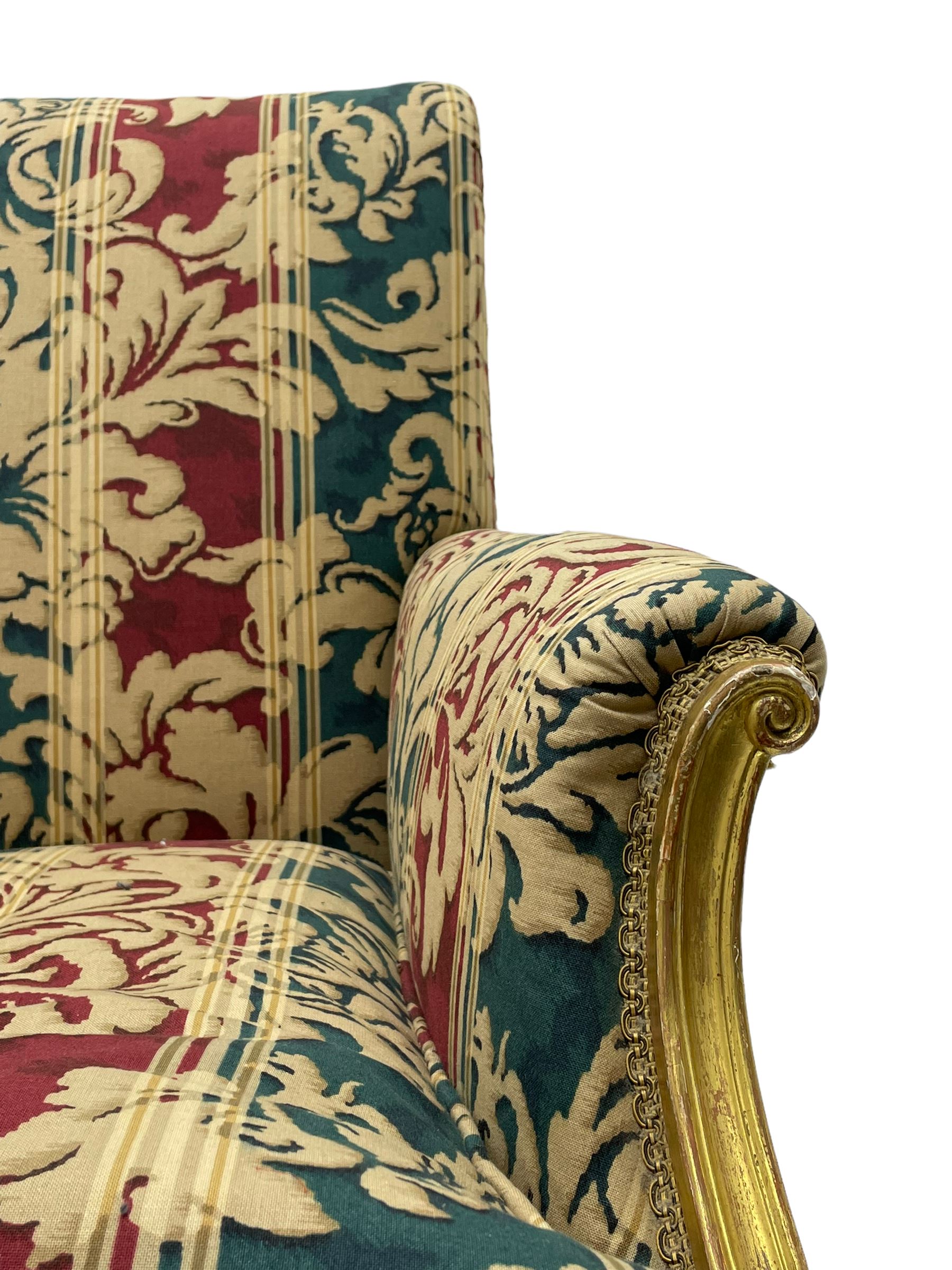 William Bertram & Son of London - pair late 19th century giltwood armchairs, moulded frame with scroll carved back and arm terminals, upholstered in striped fabric with foliate pattern, on shell carved cabriole supports, the brass castors stamped 