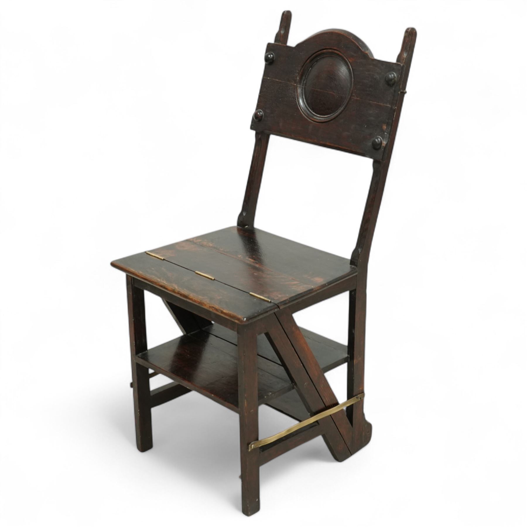 Arts & Crafts oak metamorphic chair, circular panelled back above hinged seat opening into a set of library steps with brass securing straps, circa 1900
