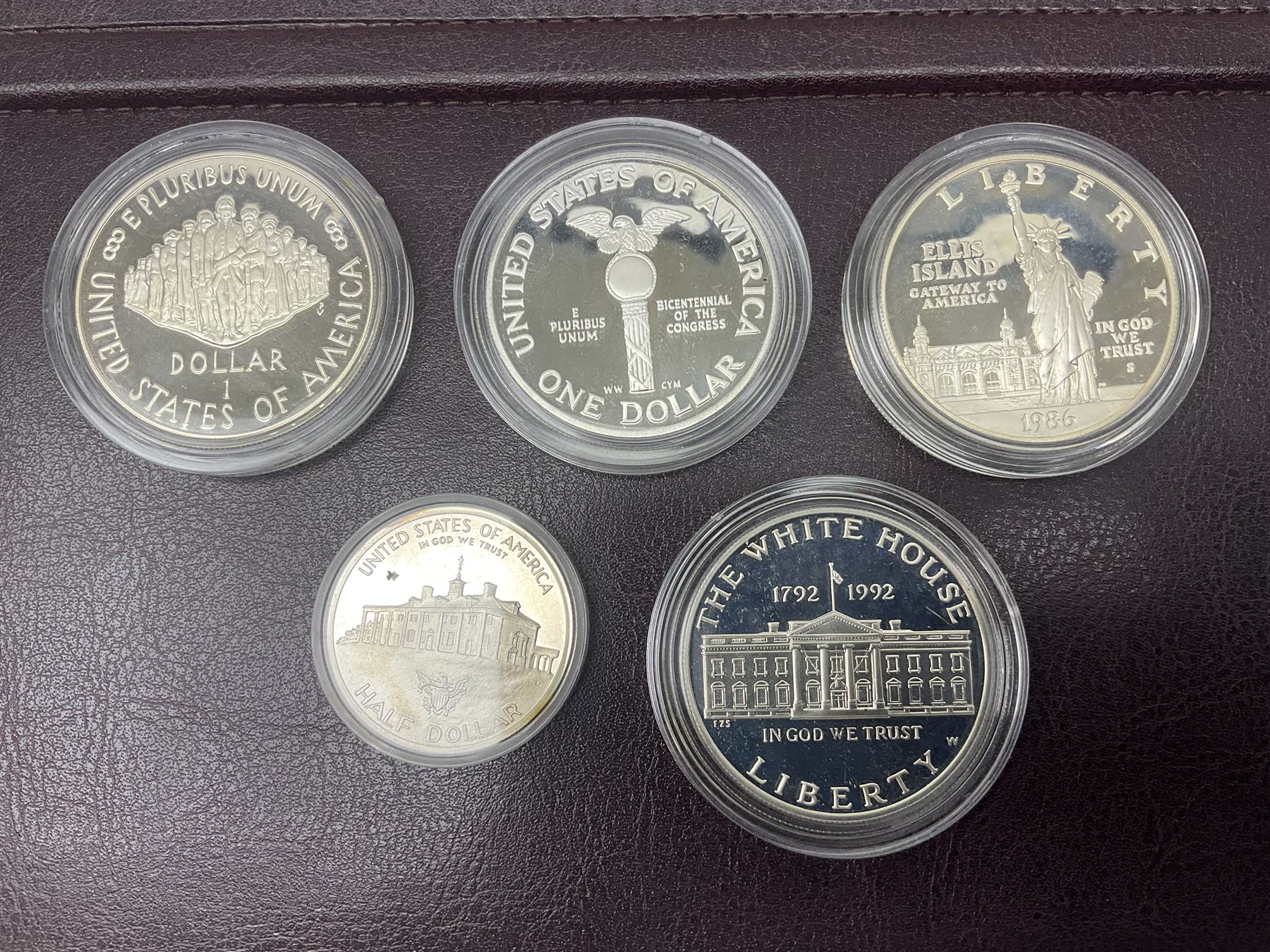 Five United States of America commemorative silver proof coins, comprising 1986, 1987, 1989, 1992 one dollars and 1982 half dollar, all with certificates