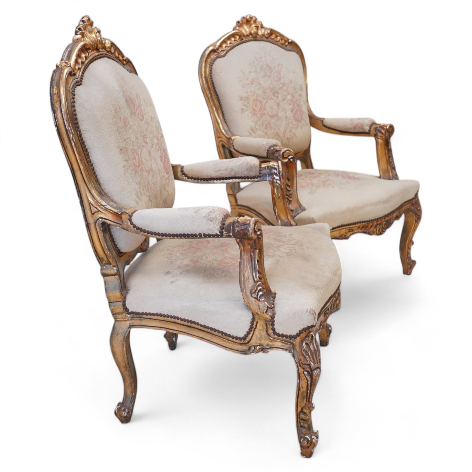 Pair of Louis XV design gilt framed armchairs, shaped cresting rail decorated with shells and foliage, upholstered in floral pattern fabric, on shell carved cabriole front supports 