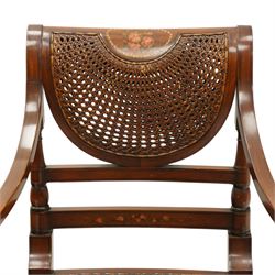 Pair of Sheraton Revival painted mahogany open armchairs, scrolled cresting rail with floral painted decoration over a double-caned back and rose-branch painted back bar, cane seat over C-scroll-painted seat rail, on splayed tapering supports, with all-over painted ebony faux stringing
