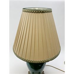 A green crackle glaze table lamp, of baluster form upon metal mounted base with four scroll feet, with beige fabric shade, overall H65cm. 