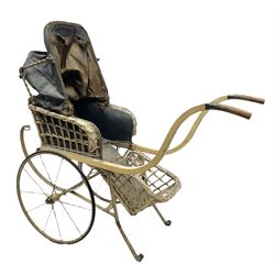 Victorian dolls canework carriage with rexine upholstered interior and folding canopy, painted wooden framework with upward curving handles, on metal sprung strapwork base and two spoked wheels with rubber tyres L90cm