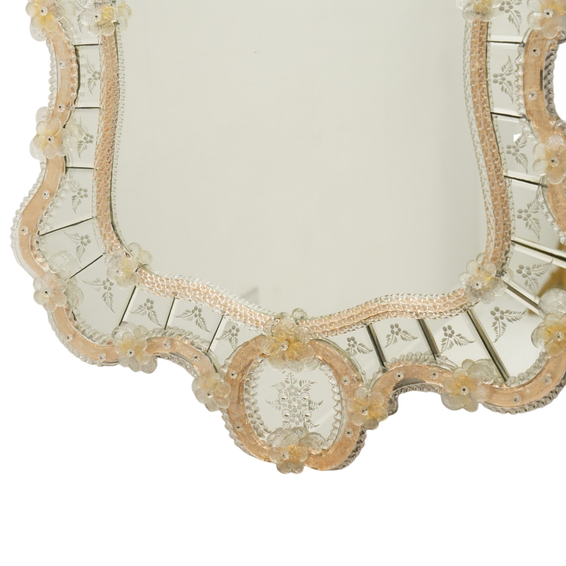 20th century Venetian glass wall mirror, the shaped plate within a mirrored frame applied with clear glass flowerheads and moulded glass edging, with etched floral decoration to the bevelled 'frameless' plates, the inner slip with ropetwist moulded glass