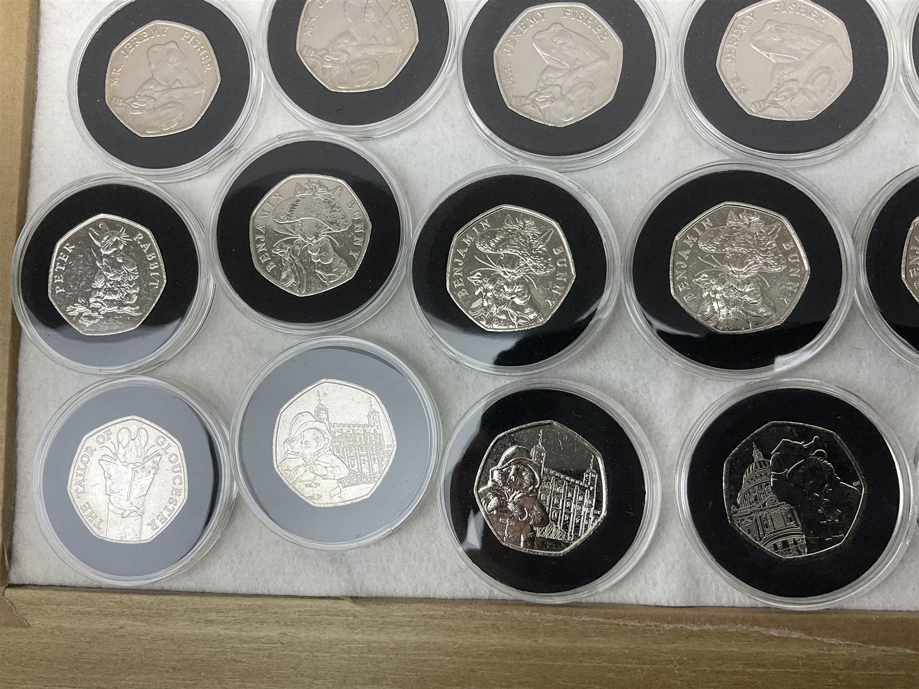 Thirty-seven commemorative fifty pence coins, including 2011 wrestling, other Olympics, Beatrix Potter etc, housed in capsules