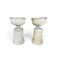 Four 20th century good quality weathered cast stone pedestal urns, circular lobed bowls with rope twist and lattice border, raised on squat base with fluted columns
