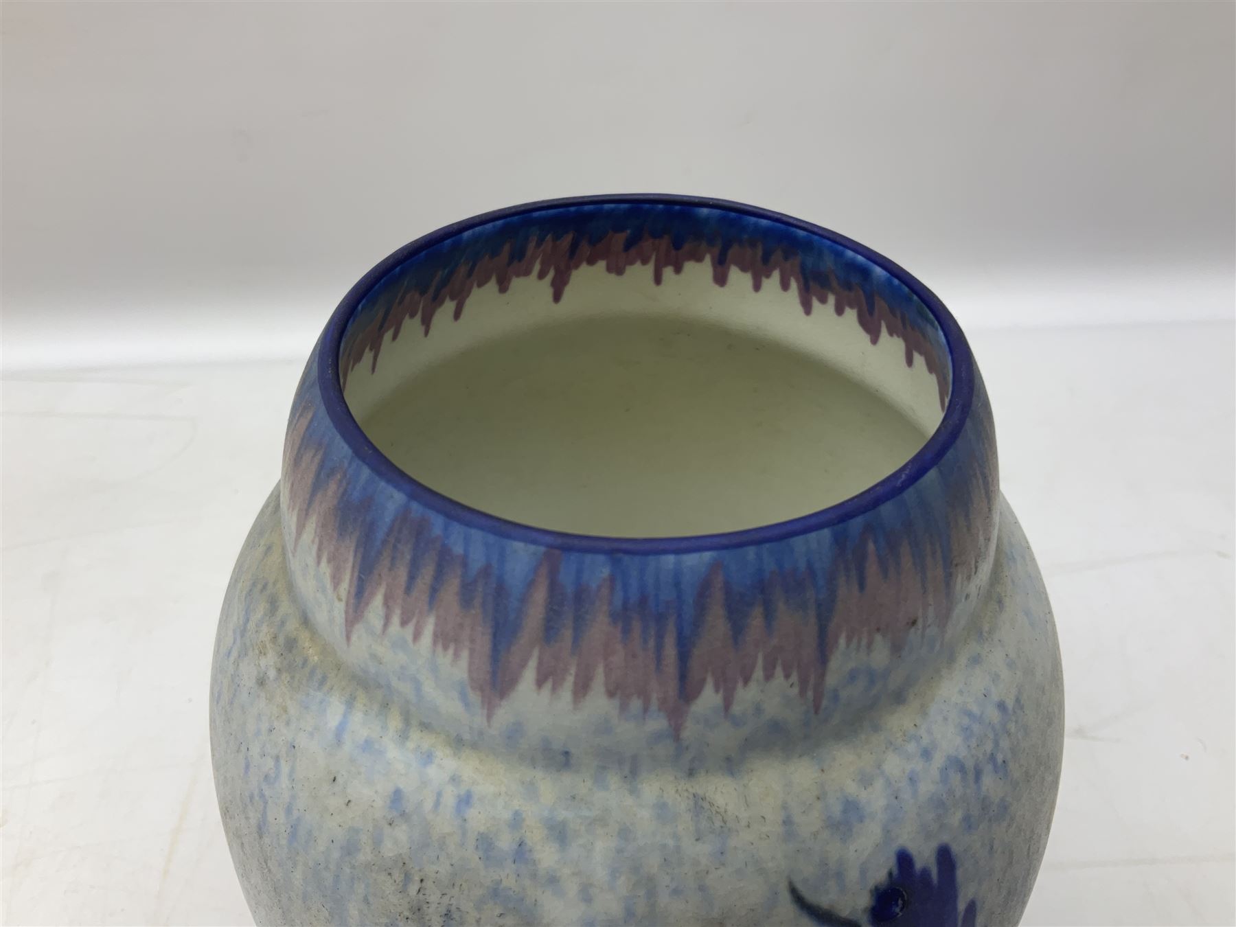 1930s Carlton Ware Art Deco Garden pattern vase of shouldered ovoid form, decorated with blue, pink and yellow flower heads on a mottled blue and white ground, pattern no. 3413, with printed and painted marks beneath, H19cm, together with a Clarice Cliff My Garden pattern vase, raised upon three feet with blue, pink and purple moulded Hollyhock design, H20cm, with Clarice Cliff Wilkinson Ltd England marks beneath