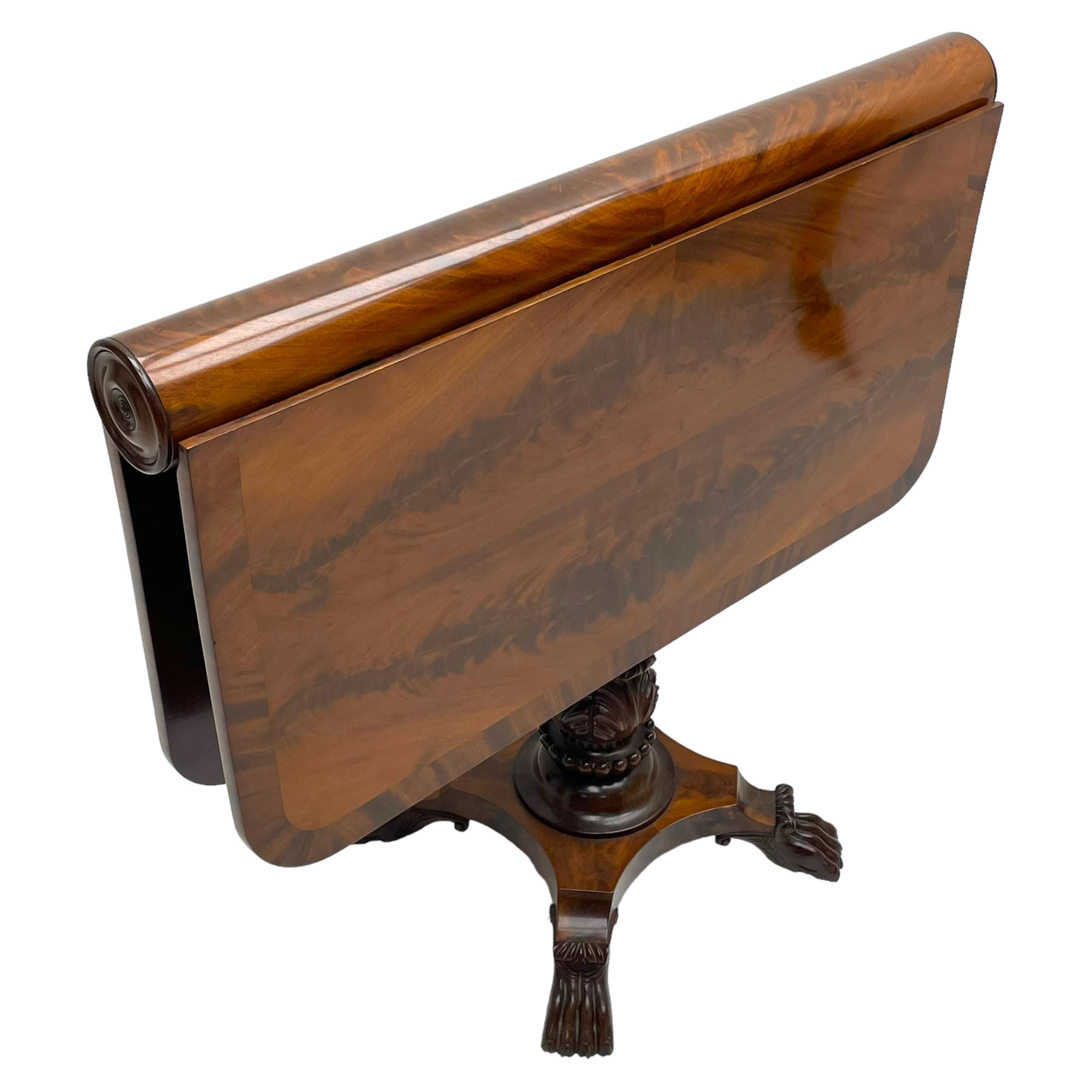 Unusual William IV mahogany Sutherland table, figured and book-matched rectangular drop-leaf top on cylindrical barrel movement, turned roundels to each end, on turned pedestal with acanthus carved baluster, shaped platform with four extended paw feet